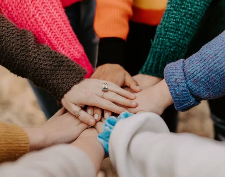 This images shows a group of people in a group huddle representing our charity fundraising efforts!