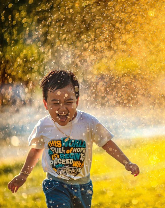 a smiling child runs through a sunbeam